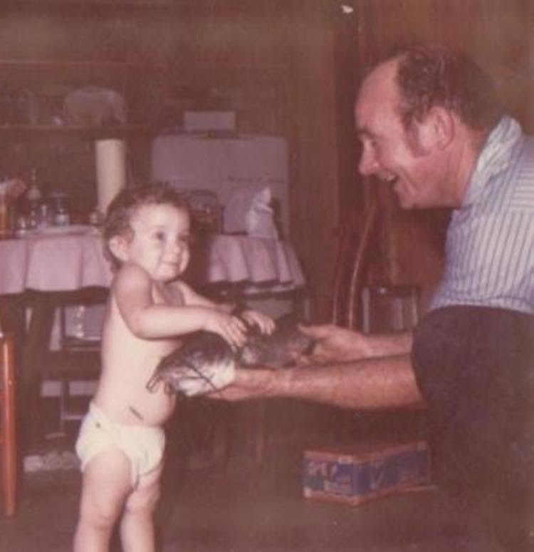 A vintage photograph of the founder as a toddler with his father.